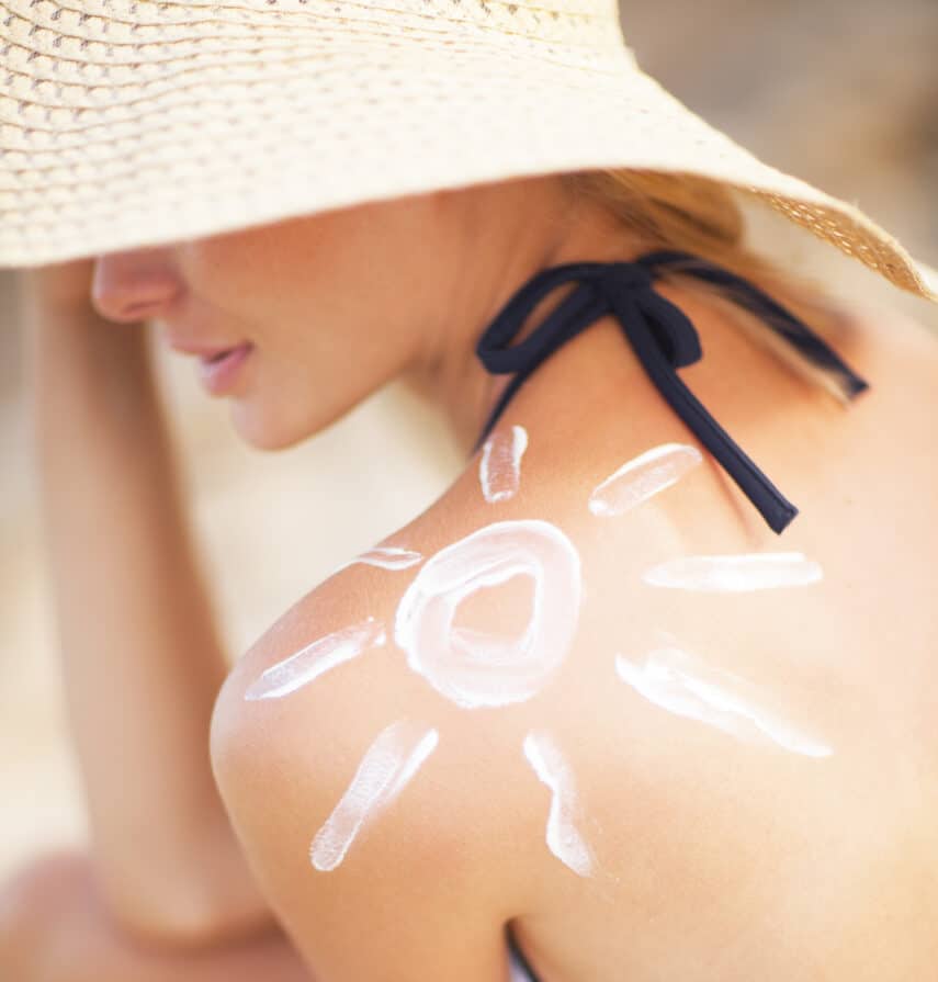 A woman with a sun painted on her shoulder in sun screen