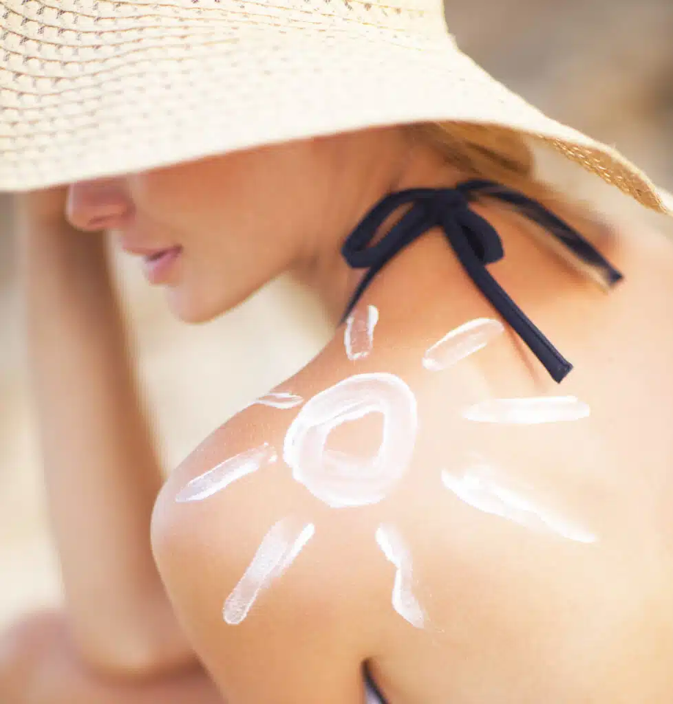 A woman with a sun painted on her shoulder in sun screen