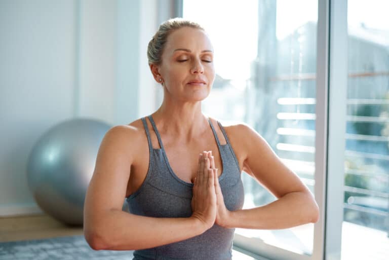 Mature woman meditating at home